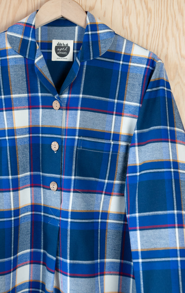 Detail shot of Women's Emilia Pajama Top in vibrant blue and white plaid with a narrow red band component, peter pan collar, white stitch details, and three coconut buttons